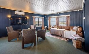 a living room with a couch and a table and chairs at Stølsdokken Lodge in Sanderstølen