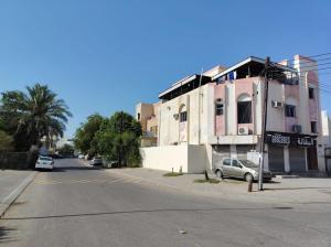 an empty street in front of a building at Turkish beach hostel in Muscat