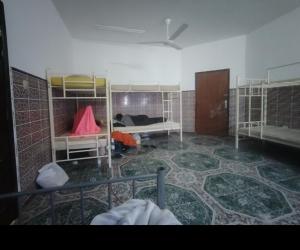 a room with two bunk beds in a room with a floor at Turkish beach hostel in Muscat