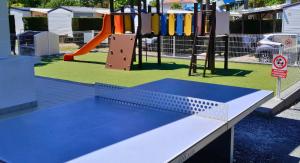 a playground with a blue table and a slide at Bungalow Camping 4 étoiles in Messanges +2 photos