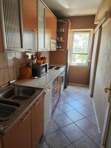 a kitchen with brown cabinets and a sink and a window at Cozy apartment in Bitola in Bitola