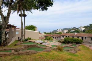 a garden with rocks and trees in a yard at Ballito Beachfront Resort - 34 Chaka Chalets in Ballito