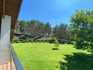 a large yard with a green lawn with trees at Pensjonat Roma in Pszczew