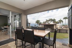 a dining room with a table and chairs on a patio at Ballito Beachfront Resort - 34 Chaka Chalets in Ballito