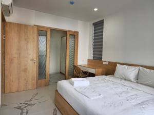 a bedroom with a large bed and a desk at Resort Long Hải in Binh Chau