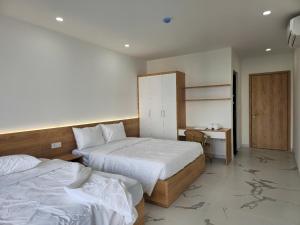 a hotel room with two beds and a desk at Resort Long Hải in Binh Chau
