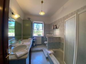 a bathroom with two sinks and a shower and a tub at Anna Rita Alghero B&B in Fertilia +39 photos