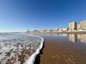 a beach with the ocean and buildings in the background at Santo Rostro Beach Apartments in Chipiona