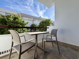 a balcony with a table and two chairs at Santo Rostro Beach Apartments in Chipiona
