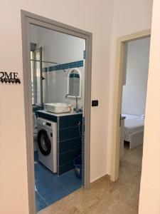 a bathroom with a washing machine and a mirror at Vila Kalluci in Borsh