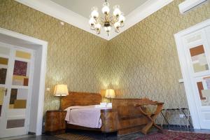 a bedroom with a bed and a chandelier at Casa Janca Pizzo in Pizzo
