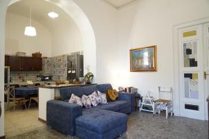 a living room with a blue couch and a kitchen at Casa Janca Pizzo in Pizzo