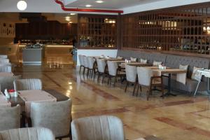 a restaurant with tables and chairs and a bar at Armas Pemar Beach in Kızılot