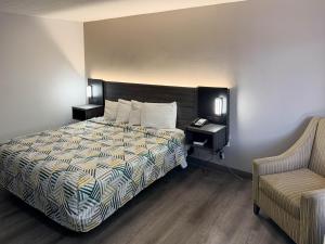 a hotel room with a bed and a chair at Motel 6 Stafford VA Quantico in Stafford