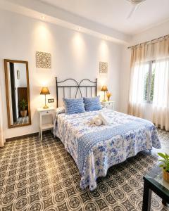 a bedroom with a bed with a blue bedspread at Hostal El Faro in Chipiona