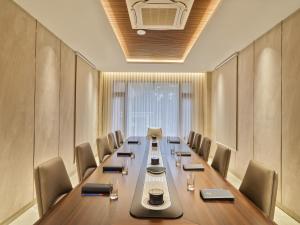 a conference room with a long table and chairs at JP Crowne Regency in Pullappalli +17 photos