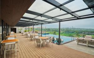 a restaurant with tables and chairs and a swimming pool at JP Crowne Regency in Pullappalli