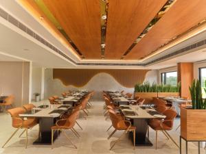 a large dining room with tables and chairs at JP Crowne Regency in Pullappalli