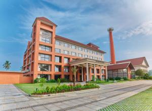 a large orange building with a clock tower on it at JP Crowne Regency in Pullappalli