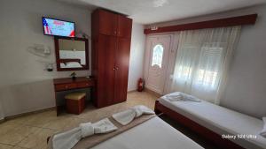 a bedroom with two beds and a television in it at studios ELENA in Potos
