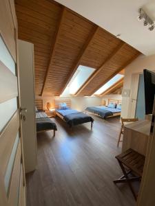 a room with two beds in a room with wooden ceilings at Pensjonat Roma in Pszczew
