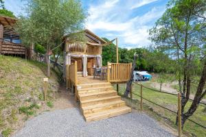 a cabin with a staircase leading up to a house at Etrusco Camping Village in Casiano