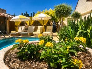 a garden with yellow flowers and umbrellas and a pool at Cabane la Clef des Champs au Mas des Entrages in Salon-de-Provence +24 photos