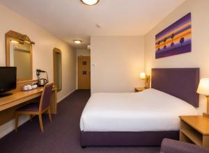 a hotel room with a bed and a desk and a computer at Middleton Inn, Manchester in Manchester +10 photos
