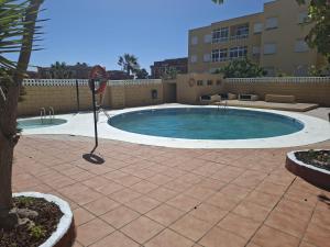 a swimming pool with a tennis racket in a courtyard at Apartamento LOLO in El Médano +15 photos