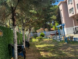 a yard with tables and chairs and a building at Kumbağ Otel in Kumbağ