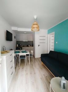 a living room with a black couch and a table at Róża Wiatrów Leśny Klif 2 in Debina