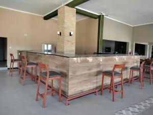 a bar with a bunch of chairs around it at GreenLand Hotel in Kasane