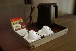 a tray with two tea cups and a kettle on a table at Hotel Hualton in Alcobendas