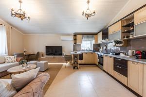 a kitchen and living room with a couch and a table at Loen Spacious Seaside Apartment 3BR Free Parking by PikHost in Durrës +47 photos