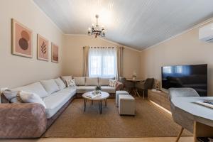 a living room with a couch and a tv at Loen Spacious Seaside Apartment 3BR Free Parking by PikHost in Durrës