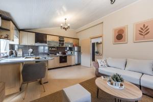a kitchen and living room with a couch and a table at Loen Spacious Seaside Apartment 3BR Free Parking by PikHost in Durrës