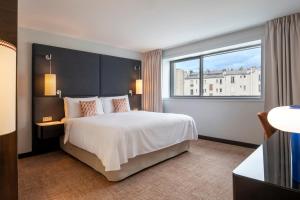a hotel room with a large bed and a window at Renaissance Paris Arc de Triomphe Hotel in Paris