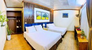 a hotel room with two beds and a table at Tam Coc Riverside Bungalow in Ninh Binh +32 photos