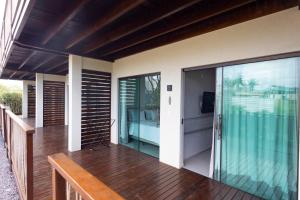 an outdoor deck with glass doors on a house at Flats do Cuca in Fernando de Noronha