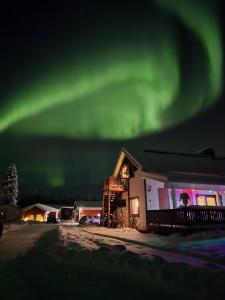 an image of the aurora in the sky over a house at Ainola Arctic Hillside in Rovaniemi