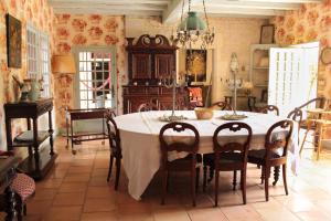a dining room with a table and a piano at Charmante Demeure 17ème 4ch-3sdb in Bioussac