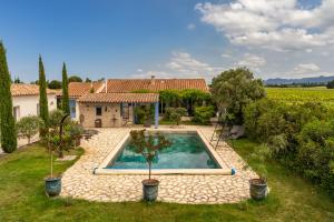 a villa with a swimming pool in a yard at Ô Dentelles in Vacqueyras