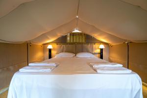 a bed in a tent with towels on it at Etrusco Camping Village in Casiano