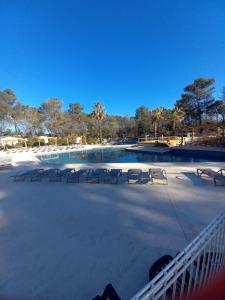 a large swimming pool with chairs in a park at Mobil Home Sainte Baume 6 personnes in Nans-les-Pins