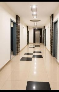 an empty hallway with black and white floors and doors at BHM Faraz hotel in Theri Sānsi