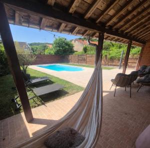 a hammock on a patio with a swimming pool at Dépendance au goût de vacances in Moulainville-la-Basse