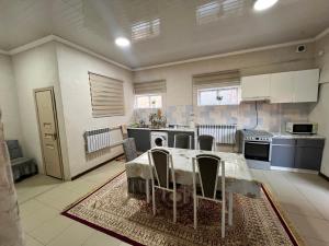 a large kitchen with a table and chairs in it at Apartmenthouse in Naryn