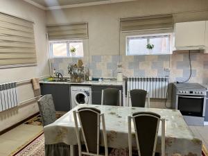 a kitchen with a table with chairs and a sink at Apartmenthouse in Naryn +17 photos