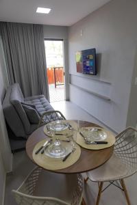 a table and chairs in a living room with a couch at Flats do Cuca in Fernando de Noronha