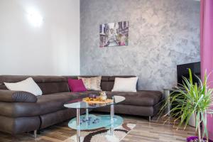 een woonkamer met een bruine bank en een tafel bij Villa Nadezda in Petrovac na Moru